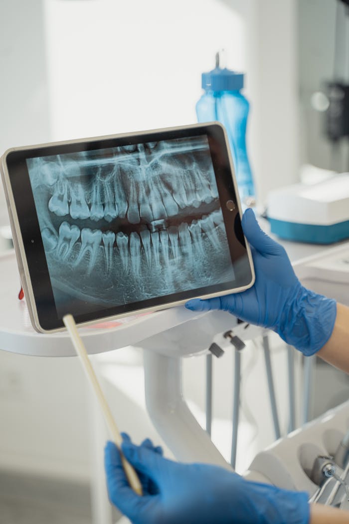 about-01 Dentist displaying dental x-ray on tablet in a modern clinic.